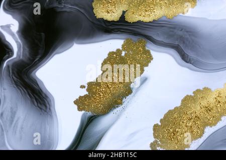 Gelber Goldstaub auf schwarzem und weißem Hintergrund verstreut. Stockfoto