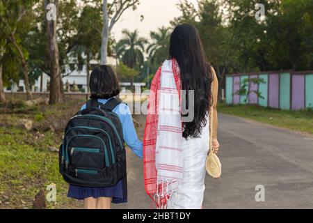 Ein indisches Schulkind, das mit ihrer Mutter zur Schule geht Stockfoto