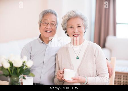Glückliches altes Paar, das zu Hause Tee trinkt Stockfoto