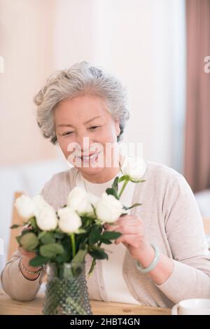 Alte Leute arrangieren Blumen zu Hause Stockfoto