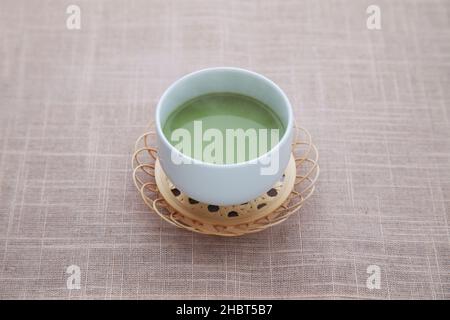 Heißer grüner Tee mit Milchmatcha Latte isoliert auf dem Tisch Stockfoto