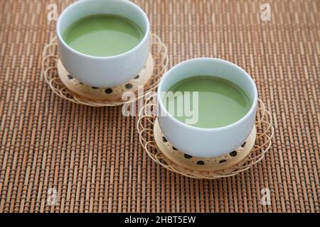 Heißer grüner Tee mit Milchmatcha Latte isoliert auf dem Tisch Stockfoto