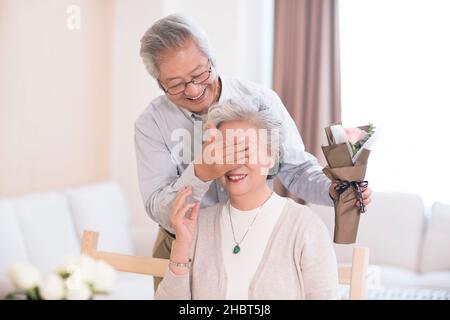 Der alte Mann sting Blumen zu seiner Frau Stockfoto