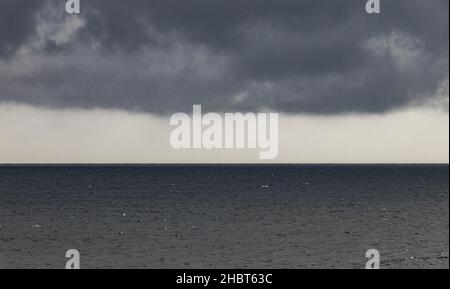 Ein schöner Blick auf die Wolkenlandschaft über die Meereswellen bei Sonnenaufgang Stockfoto