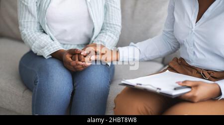 Therapeutin, die weibliche Patientin psychologische Hilfe leistet, ihre Hand in der Klinik hält, beschnittene Ansicht. Bannerdesign Stockfoto