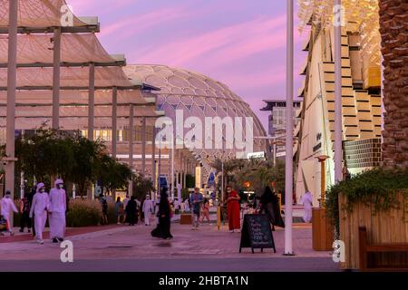 Dubai, VAE, 09.12.2021. Al Wasl Plaza Kuppel und Straße mit Menschen zu Fuß auf der Expo 2020 Dubai, rosa Himmel Sonnenuntergang im Hintergrund. Stockfoto