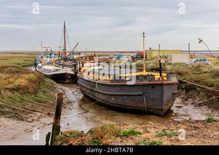 Lastkähne und Boote, die in Low Tide an der Mündung des Flusses Medway in Upchurch in Kent, England, angesetzt wurden Stockfoto