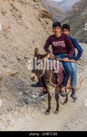 HAFT KUL, TADSCHIKISTAN - 10. MAI 2018: Jungen auf einem Esel in Marguzor Haft Kul in den Fann-Bergen, Tadschikistan Stockfoto