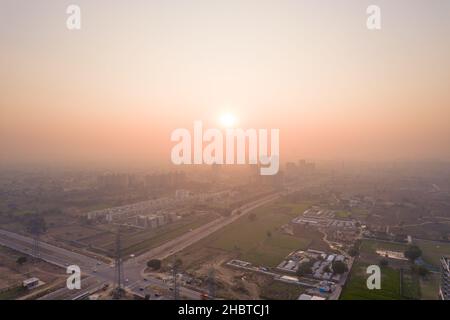 Luftdrohne schoss über ein Gebäude mit Häusern, Büros und Einkaufszentren, die sich vor Sonnenuntergang in Richtung Skyscaper bewegten und die Leere zeigten Stockfoto