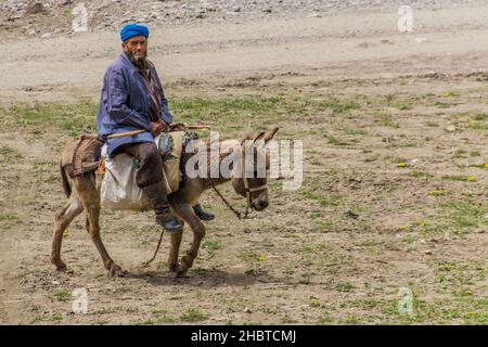 HAFT KUL, TADSCHIKISTAN - 11. MAI 2018: Alter Mann auf einem Esel in Marguzor Haft Kul im Fann-Gebirge, Tadschikistan Stockfoto