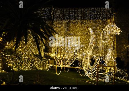 Kroatien, Rijeka 12-2021.beleuchtete Weihnachtskutschendekoration im Park. Weihnachtliche Lichtdekorationen. Christmaskridges Märchen aus Draht. Stockfoto