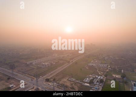 Luftdrohne schoss über ein Gebäude mit Häusern, Büros und Einkaufszentren, die sich vor Sonnenuntergang in Richtung Skyscaper bewegten und die Leere zeigten Stockfoto