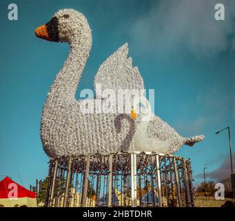 Stratford-upon-Avon, Großbritannien - Eine wunderbare Straßendekoration mit einem Schwan und einem Signet, die inmitten der Stände des viktorianischen Weihnachtsmarktes stehen. Stockfoto