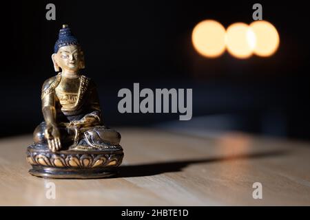 Eine Nahaufnahme einer kleinen Buddha-Statue auf dem Tisch Stockfoto