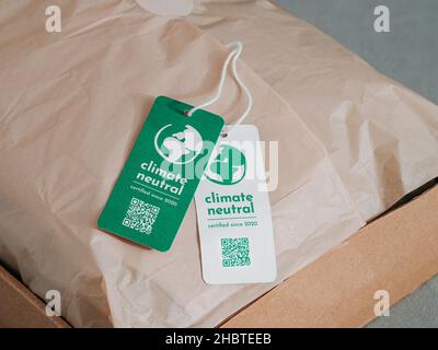 Klimaneutrales Produkt in Craft-Wellpappe mit Etikett Klimaneutral. Klimaneutrales Label-Konzept in den Bereichen Bekleidung, Mode, Logistik und ethischer Konsum. Erhöhung des Bewusstseins für Kunden über CO2-Fußabdruck Stockfoto