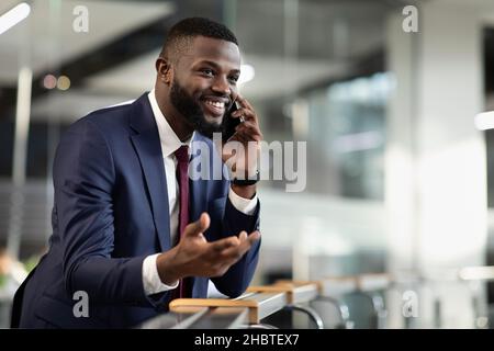 Wohlhabender afroamerikanischer Unternehmer, der Telefongespräche führt Stockfoto