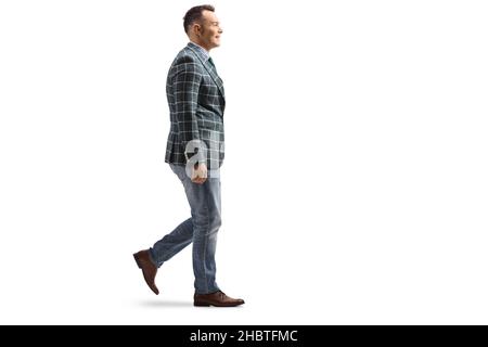 Ganzkörperaufnahme eines jungen Mannes in Jeans und stilvollem Anzug, der isoliert auf weißem Hintergrund läuft Stockfoto