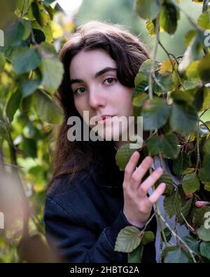 Teenager, die von Bäumen umgeben steht Stockfoto
