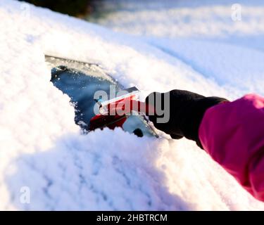 Fahrer räumt Schnee von der Windschutzscheibe Stockfoto