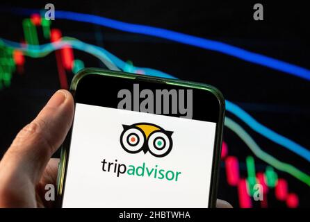China. 09th Dez 2021. In dieser Abbildung sehen Sie das Logo des amerikanischen Reisebüros und Restaurants auf der Website des Unternehmens TripAdvisor, das auf einem Smartphone mit einem Index der Wirtschaftskurse im Hintergrund angezeigt wird. (Foto von Budrul Chukrut/SOPA Images/Sipa USA) Quelle: SIPA USA/Alamy Live News Stockfoto