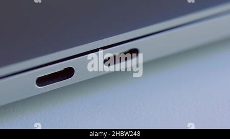 Nahaufnahme von eleganten, modernen Laptop-Details. Konzept moderner Technologien, USB-Anschluss eines Computers auf weißer, flacher Oberfläche. Stockfoto