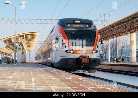 Ein moderner Stadler-Elektrozug kommt am Bahnhof an. Klarer Wintertag. Helle Farben. Nahaufnahme Stockfoto