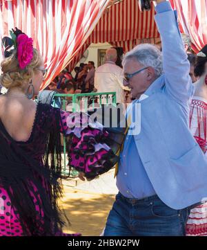 Sevilla, Provinz Sevilla, Andalusien, Südspanien. Feria de Abril, die Aprilmesse. Reifes Paar tanzt Flamenco. Stockfoto