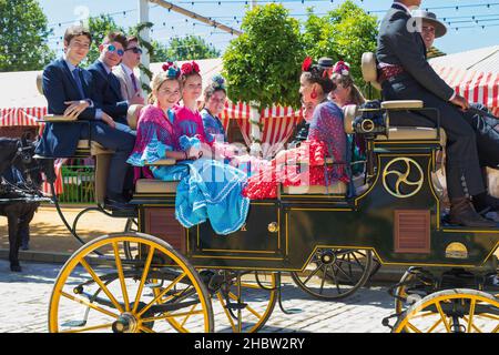 Sevilla, Provinz Sevilla, Andalusien, Südspanien. Feria de Abril, die Aprilmesse. Pferde- und Kutschenparade. Junge, fröhliche Besucher lächeln vor die Kamera Stockfoto