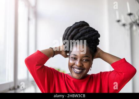 Porträt einer lächelnden jungen Frau in Innenräumen Stockfoto