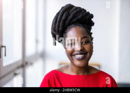 Porträt einer lächelnden jungen Frau in Innenräumen Stockfoto