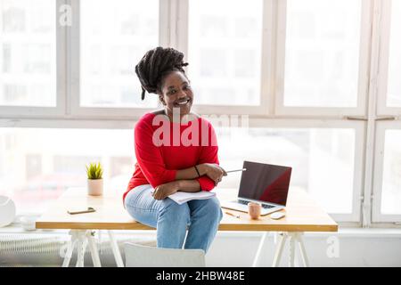 Junge Frau, die in einem kreativen Start-up-Unternehmen arbeitet Stockfoto