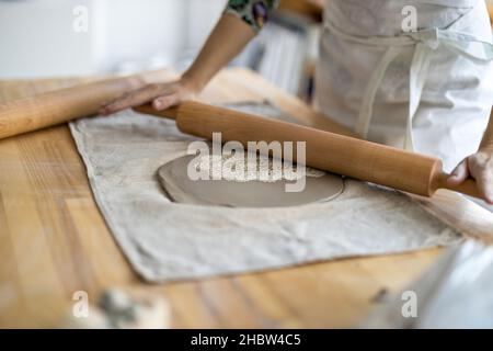 Nahaufnahme der Handwerkerin, die in der Werkstatt an ihrer Töpferei arbeitet Stockfoto