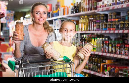 Schwanger mit ihrem Kind zeigen ihre Wahl in der Lebensmittelabteilung Stockfoto