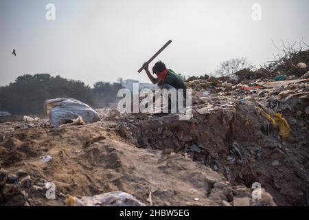 Gurugram, Indien. 21st Dez 2021. Ein junger Fetzen-Picker sah, wie er auf einer Deponie in Cyber City nach wiederverwendbaren Gegenständen suchte. Kredit: SOPA Images Limited/Alamy Live Nachrichten Stockfoto