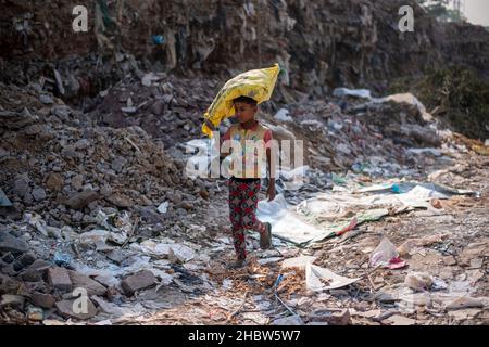 Gurugram, Indien. 21st Dez 2021. Ein junger Fetzen-Picker sah, wie er einen Müllsack trug, während er in Cyber City nach wiederverwendbaren Gegenständen suchte. (Foto von Pradeep Gaur/SOPA Images/Sipa USA) Quelle: SIPA USA/Alamy Live News Stockfoto