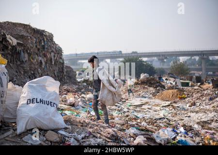 Gurugram, Indien. 21st Dez 2021. Ein junger Fetzen-Picker sah, wie er einen Müllsack trug, während er auf einer Deponie in Cyber City nach wiederverwendbaren Gegenständen suchte. (Foto von Pradeep Gaur/SOPA Images/Sipa USA) Quelle: SIPA USA/Alamy Live News Stockfoto