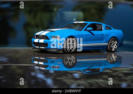 Spiegelung des Modellspielzeugs Mustang auf einer echten Mustang Autohaube beim Tahitótfalu Mustang Festival Stockfoto