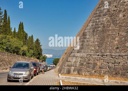 Kerkyra, Korfu, Griechenland - 31. Juli 2021: Autos parkten entlang uneinnehmbarer Mauern der mittelalterlichen Neuen Festung in der Altstadt. Es handelt sich um eine venezianische Festung aus dem Jahr 1815 Stockfoto