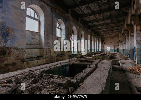 Wand mit gewölbten Fenstern in verlassenen und ruinierten Zuckerfabrik. Stockfoto