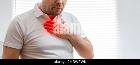 Der junge Mann leidet unter Sodbrennen. Erkrankung des Magen-Darm-Traktes. Halsschmerzen. Stockfoto