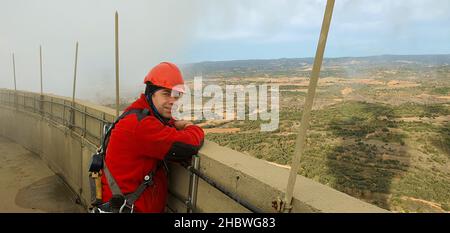 Arbeiter mit Gurtzeug und Helm, der in der Höhe arbeitet Stockfoto