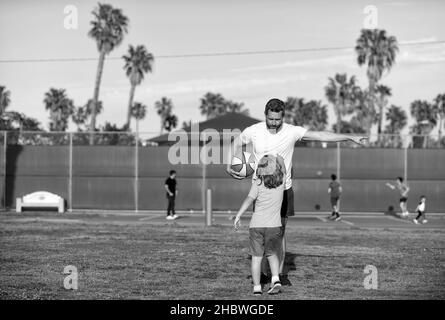 Junge Kind hören Mann Trainer erklären Basketballregeln auf Sportplatz, Sporttraining Stockfoto