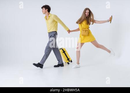 Schönes junges Paar mit Reisetasche, die Hand in Hand geht Stockfoto
