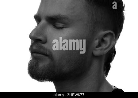 Ein schwarz-weißes Porträt eines hübschen Mannes mit geschlossenen Augen. Stockfoto