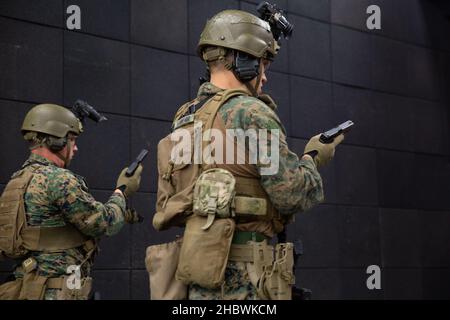 U.S. Marine Corps Sgt. Jim Steele, Left, ein CQB-Instruktor (engl.: Close-Quarters Battle) mit Training Company und CPL. Luke Schriever, rechts, ein Vorgesetzter und Teamleiter der Rückgewinnungstaktik, beide zusammen mit dem Marine Corps Security Force Regiment, führt während der Übung Tartan Eagle Phase II, Northumbria Police Range, Wallsend, England, 12. Dezember, taktische Nachladungen mit einem Glock 17 durch. 2021. Der Bereich erlaubte es den britischen CQB-Instruktoren der Royal Marine, den US-Marineinfanteristen verschiedene Schießtechniken vorzustellen, was sie dazu veranließ, neue Wege zu entwickeln und zu entdecken, um einen Feind in unmittelbarer Nähe zu engagieren. Übung Tar Stockfoto