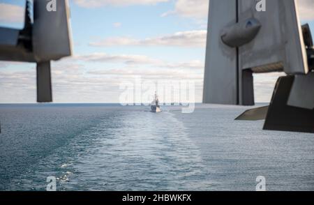 211220-N-PG226-1065 MEDITTERANIAN SEA (DEZ 20, 2021) der Lenkflugzeugkreuzer USS San Jacinto (CG 56) der Ticonderoga-Klasse und die Royal Norwegian Navy Frigate HNoMS Fridtjof Nansen (F310) fahren hinter dem Flugzeugträger USS Harry S. Truman (CVN 75) der Nimitz-Klasse, 20. Dezember 2021. Die Harry S. Truman Carrier Strike Group ist im Rahmen eines geplanten Einsatzgebiets der Sechsten Flotte der USA zur Unterstützung von Marineoperationen im Hinblick auf die Aufrechterhaltung der Stabilität und Sicherheit im Seeverkehr sowie die Verteidigung der Interessen der USA, der Alliierten und Partner in Europa und Afrika im Einsatz. (USA Navy Foto von Mass Communication Specialist 3rd Class Stockfoto