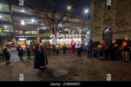 Wilkes Barre, Usa. 21st Dez 2021. Ein Priester, der eine Kerze hält, schließt die längste Nachtwache in einem Kreis von Gemeindemitgliedern. In der längsten Nacht, der Wintersonnenwende, wenn der Tag am kürzesten ist, werden sich Gemeinden versammeln und eine Mahnwache abhalten, um an Obdachlose zu erinnern, die auf der Straße gestorben sind. Die St.-Stephans-Kirche in Wilkes-Barre hielt die Mahnwache für das Jahr 20th und fügte 6 neue Namen für das Jahr 2021 hinzu. Kredit: SOPA Images Limited/Alamy Live Nachrichten Stockfoto