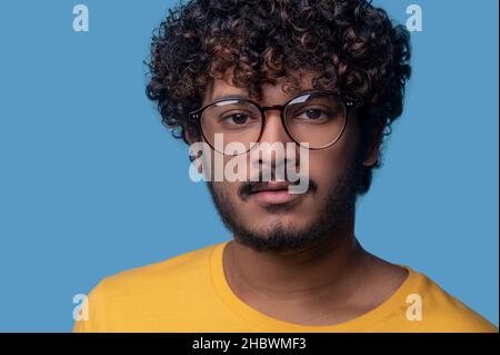 Gelassener Mann in einer trendigen Brille, der nach vorne starrt Stockfoto