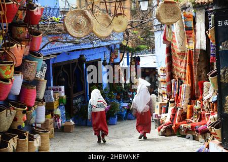 Traditionell gekleidete marokkanische Frauen gehen in der alten Medina von Chefchaouen, Marokko. Stockfoto