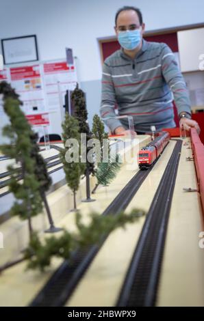 Darmstadt, Deutschland. 17th. November 2021. Auf der Modellanlage im Darmstädter Eisenbahnverkehrsfeld (EBD) können auch Bäume per Fernbedienung über die Schiene gelegt werden, um unerwartete Szenarien abbilden zu können. Im Hintergrund beobachtet Holger Kötting, technischer Leiter der Anlage, wie der Zug langsamer wird. Die Simulationsanlage soll möglichst viele verschiedene Betriebssituationen auf der realen Bahn realistisch reproduzieren. (To dpa 'Training mit Spielzeuglokomotive - Modelleisenbahn hilft bei der Signalkastenarbeit') Quelle: Frank Rumpenhorst/dpa/Alamy Live News Stockfoto